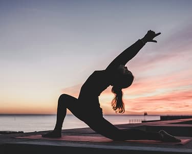 Woman practicing yoga on the beach